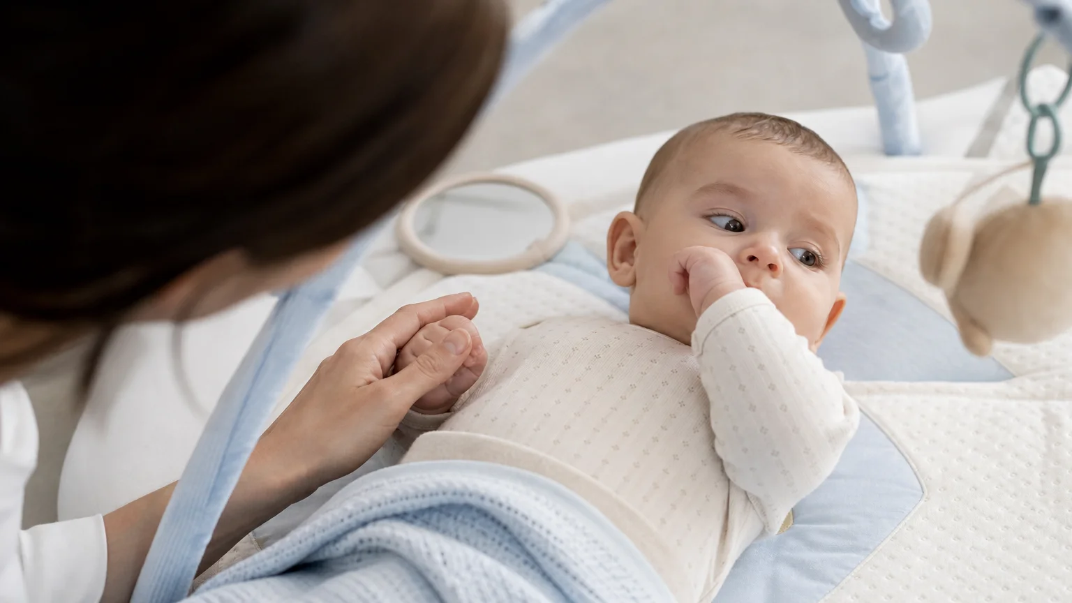 Parent observant les signes de fatigue d’un bébé avant la sieste