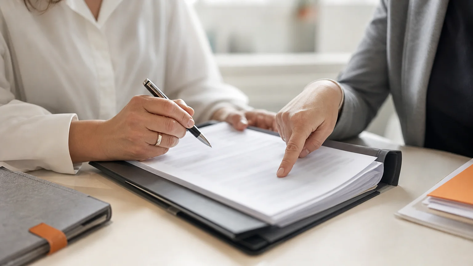 Mains non identifiables préparant et signant des documents juridiques