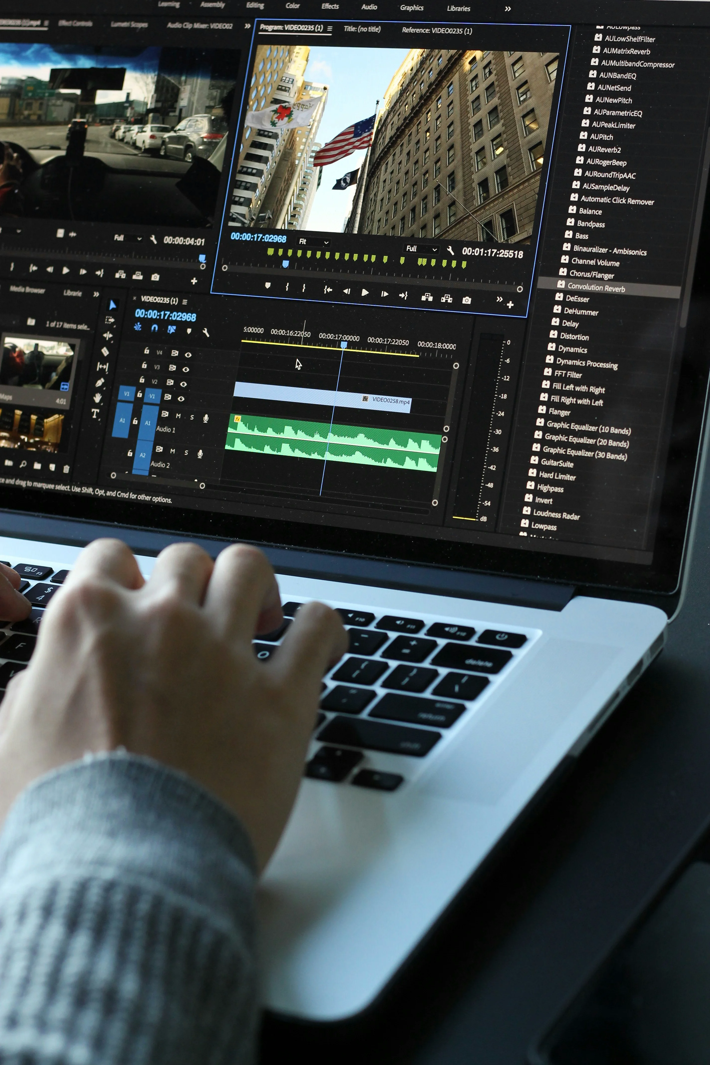 Main utilisant un ordinateur portable avec un logiciel de montage vidéo et une timeline