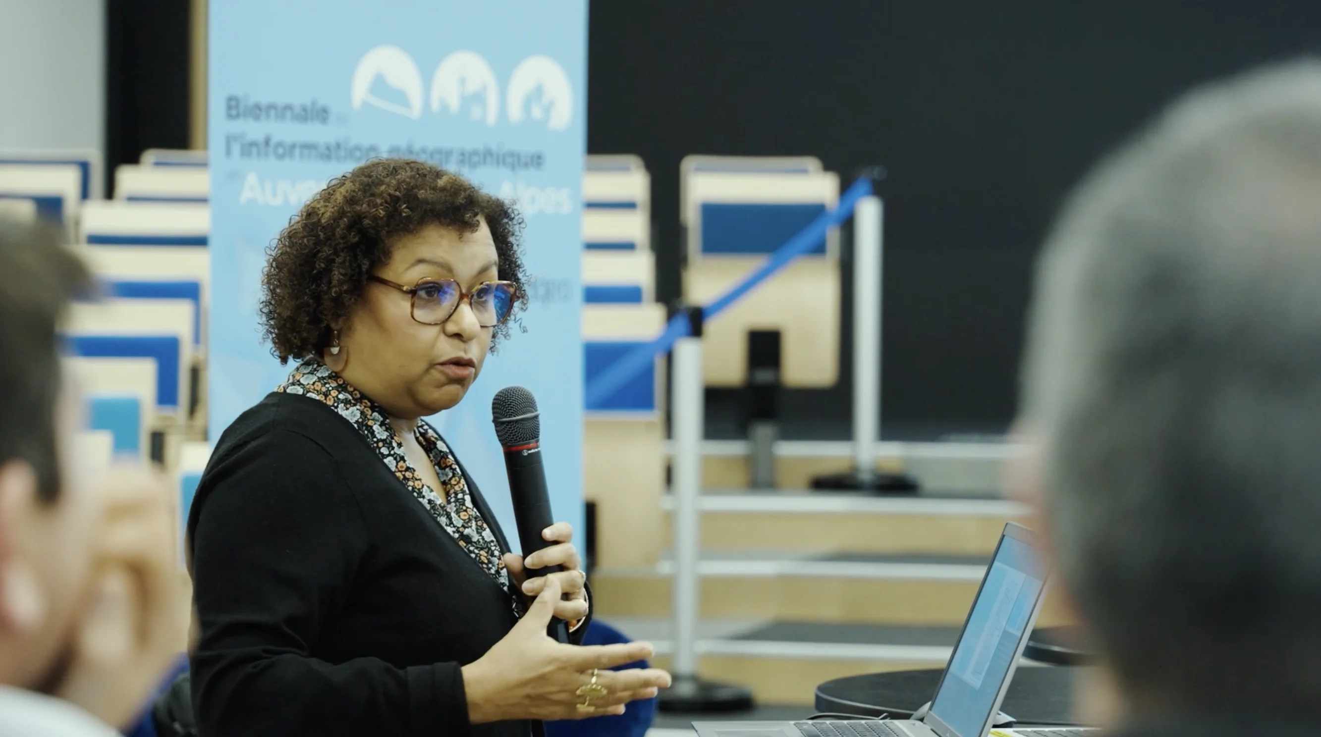 Intervenant présentant un sujet devant un public dans une salle de conférence
