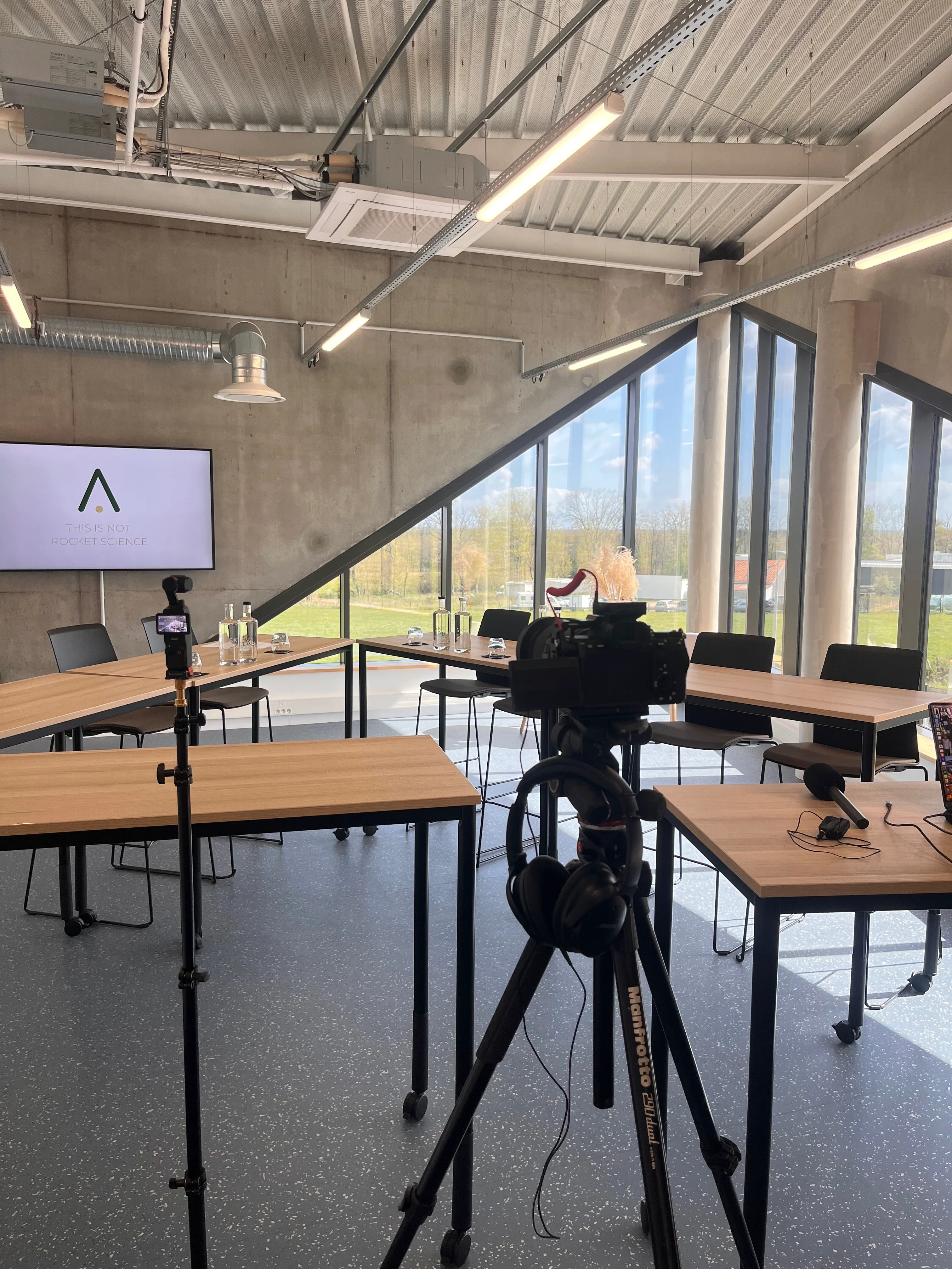 Salle lumineuse aménagée avec des tables, des chaises et du matériel de production vidéo