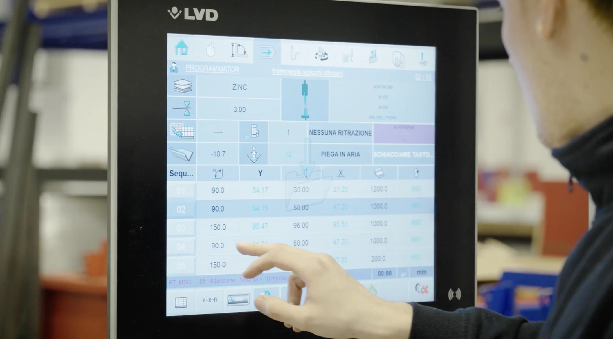 Main d’un opérateur utilisant un écran tactile de commande sur une machine industrielle