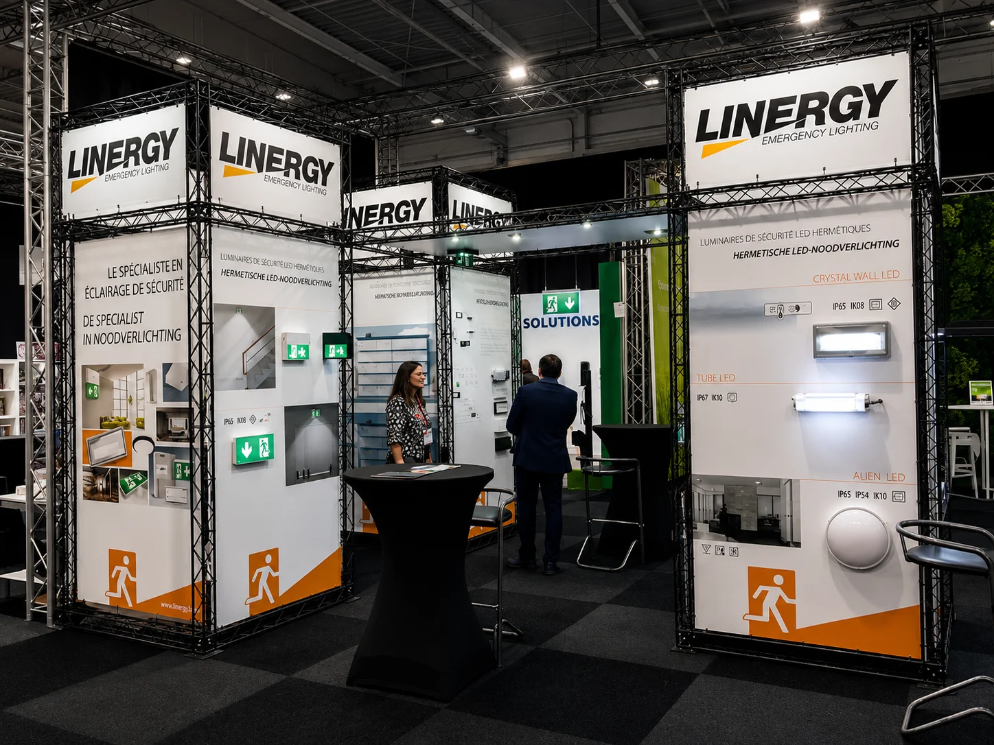 Stand de salon avec panneaux de marque, produits d’éclairage et supports d’information.