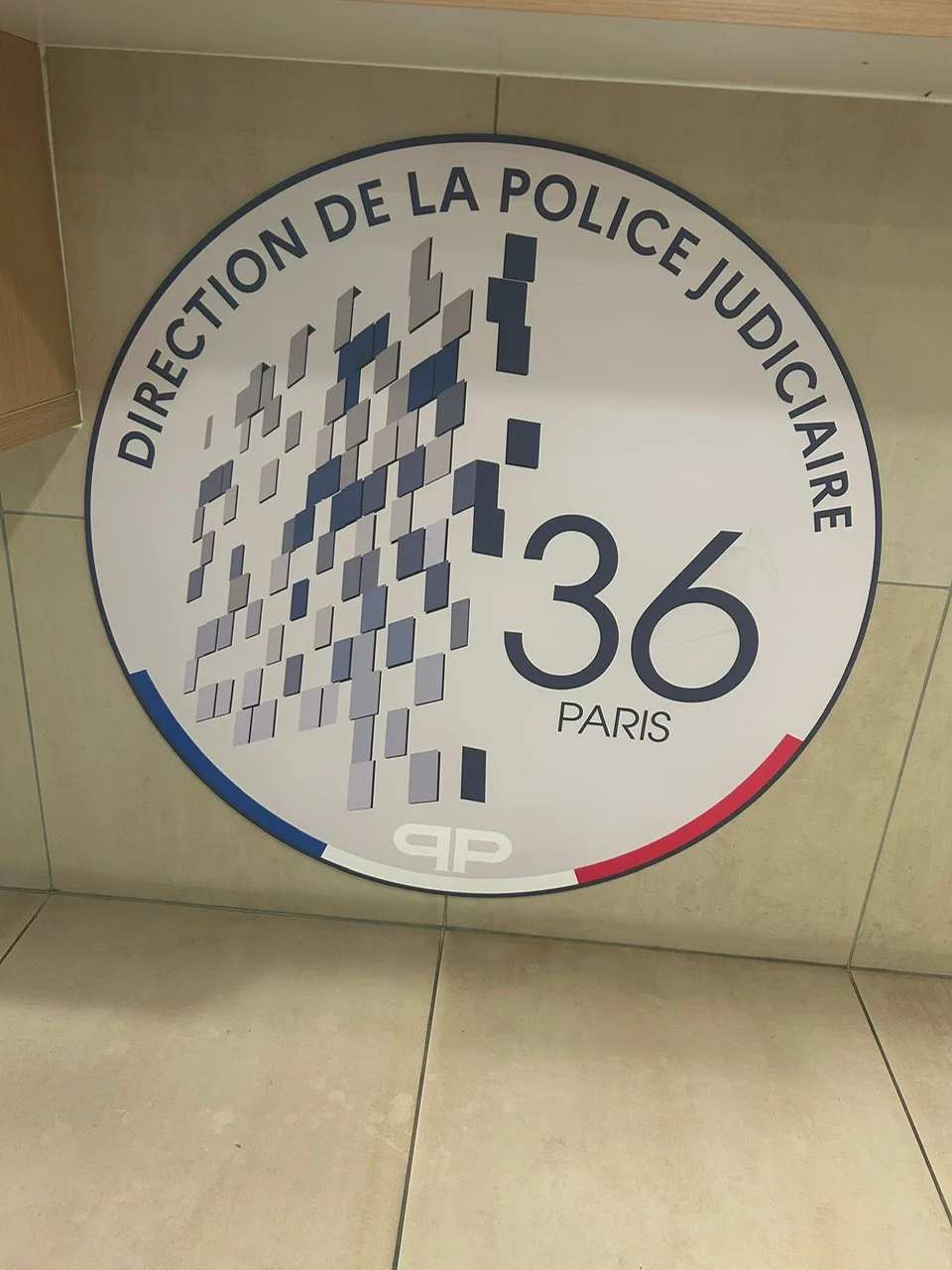 Panneau circulaire indiquant la Direction de la police judiciaire, 36 Paris.